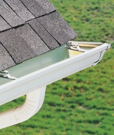 Freshly cleaned white aluminum gutter system showcasing clear channels and proper drainage slope along a Minnetonka home roofline